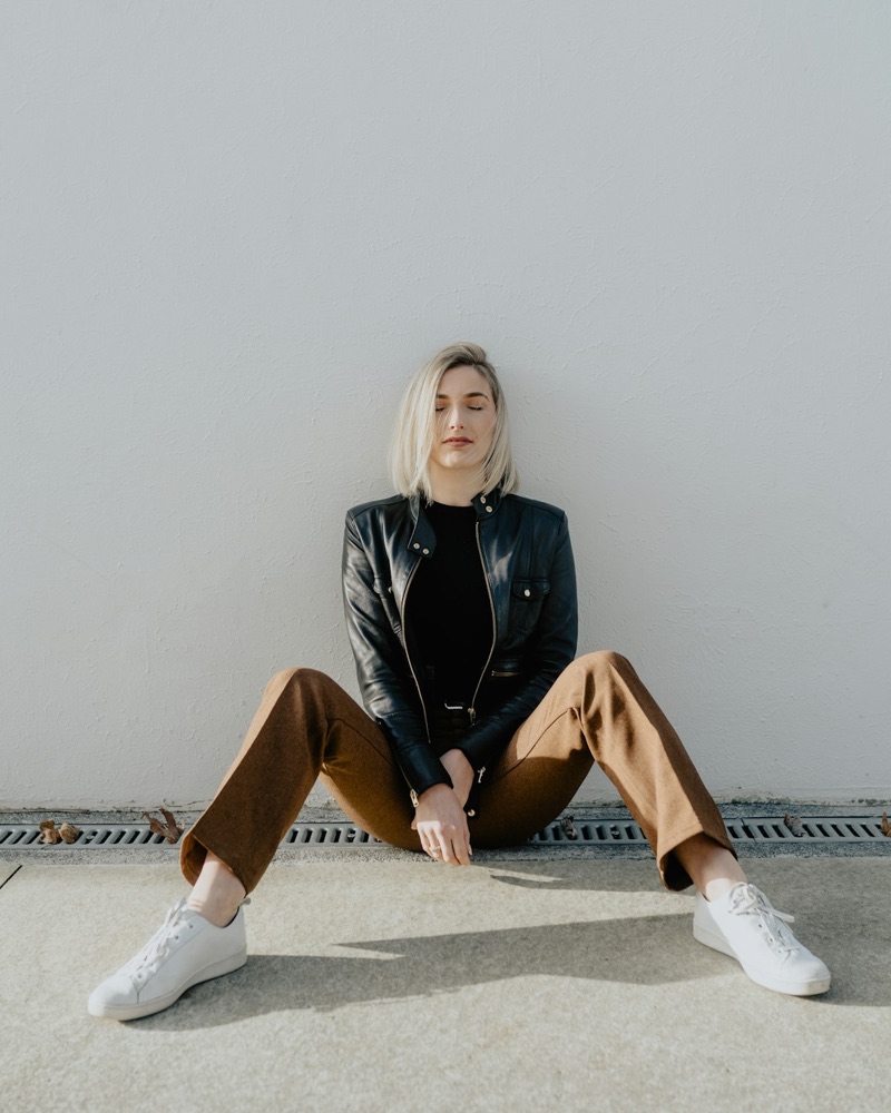 Similar black jacket with gold hardware worn with camel trousers
